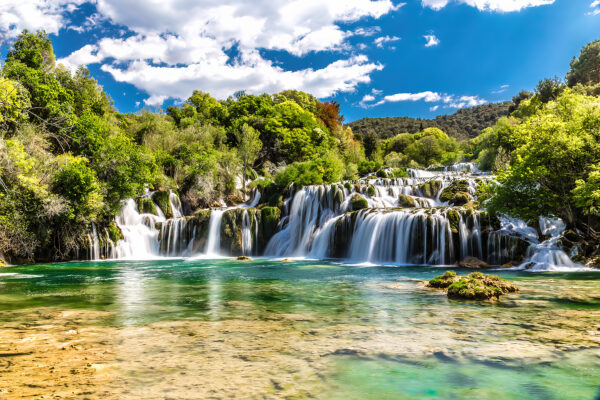 Εθνικό πάρκο Krka περιτριγυρισμένο από δέντρα και γαλάζιο ουρανό Εθνικό πάρκο Krka περιτριγυρισμένο από δέντρα και γαλάζιο ουρανό