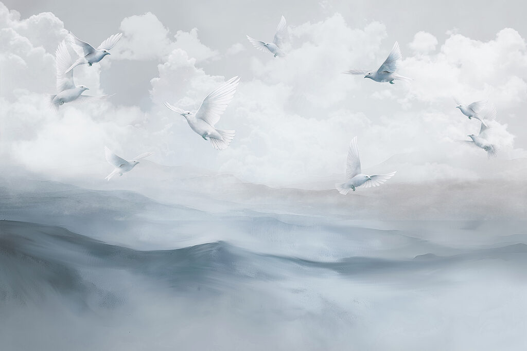 Group of white birds flying over a mountain