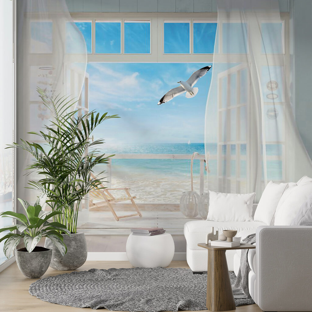 View of a beach from a room with a bird flying over it