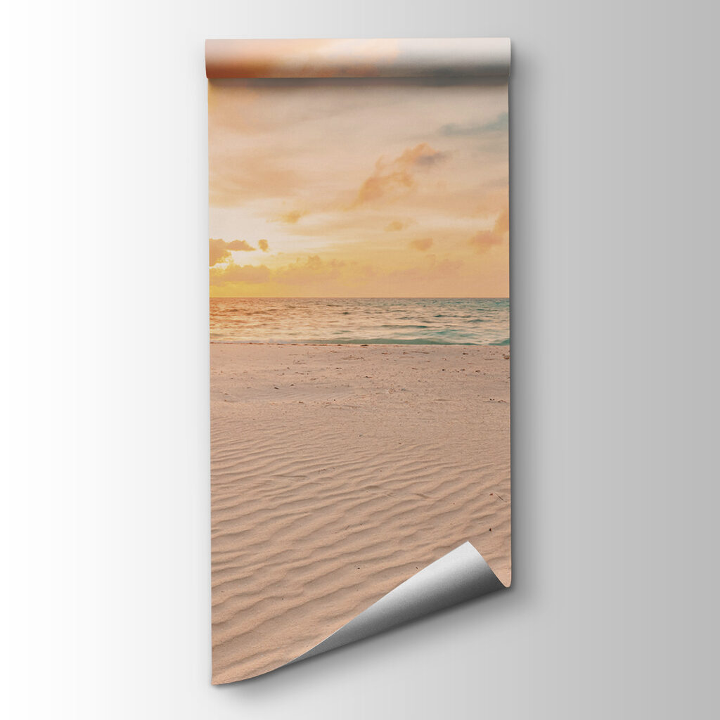 A sandy beach with waves and a sunset